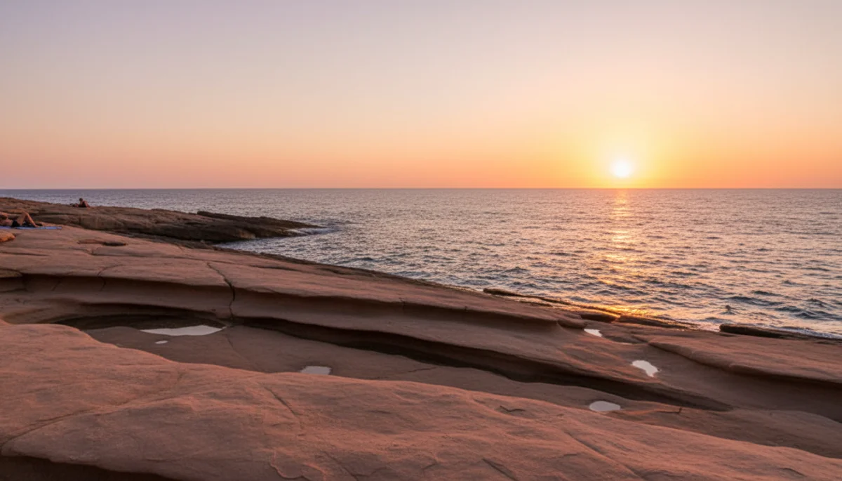 Flat rocky platforms at Punta Galera at sunset with a pink sky