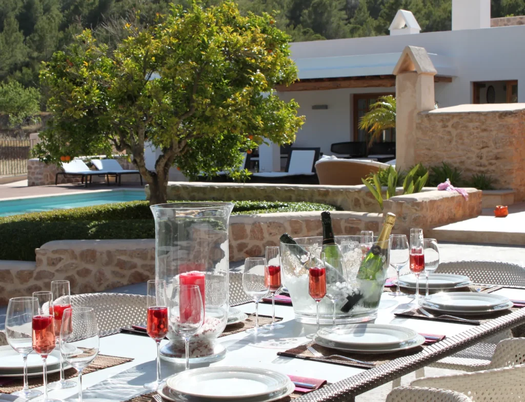Mesa puesta en la terraza de una villa de Ibiza Rural Villas, con la piscina y el campo al fondo