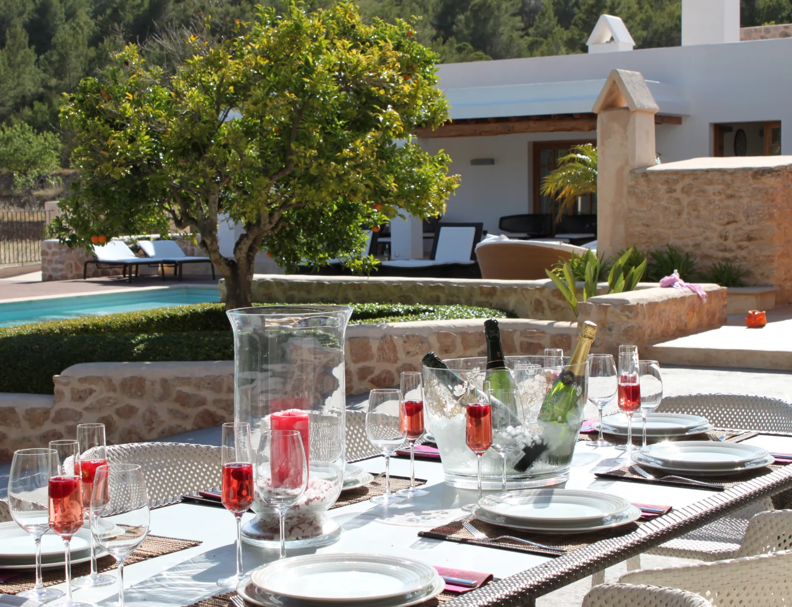 Mesa puesta en la terraza de una villa de Ibiza Rural Villas, con la piscina y el campo al fondo