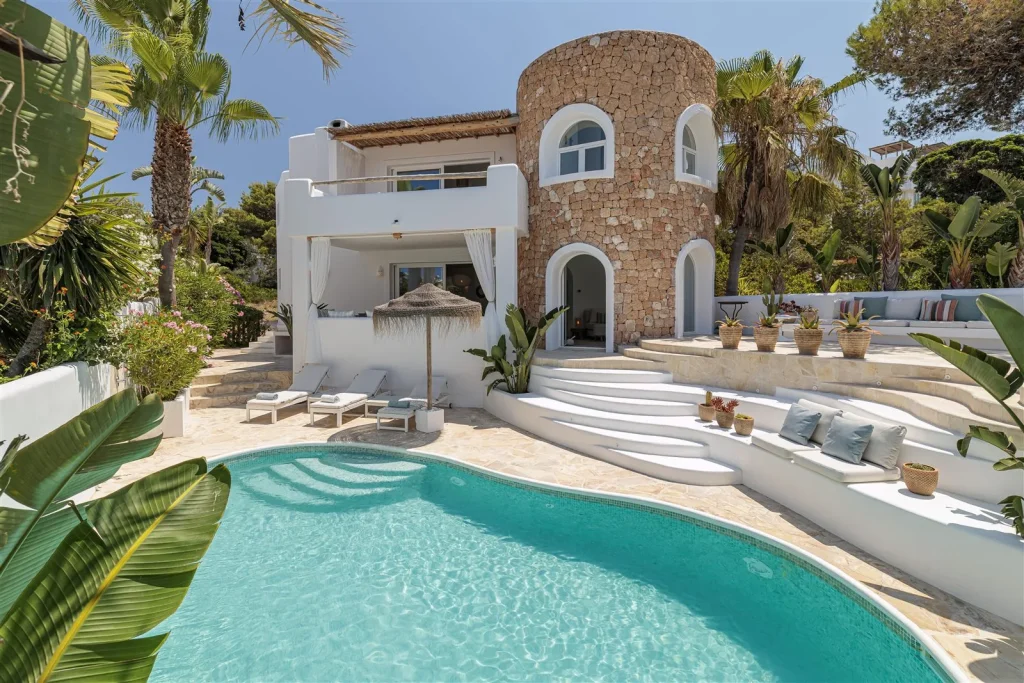 Piscina privada de Casa Cala Vadella en Ibiza, con la torre de piedra al fondo